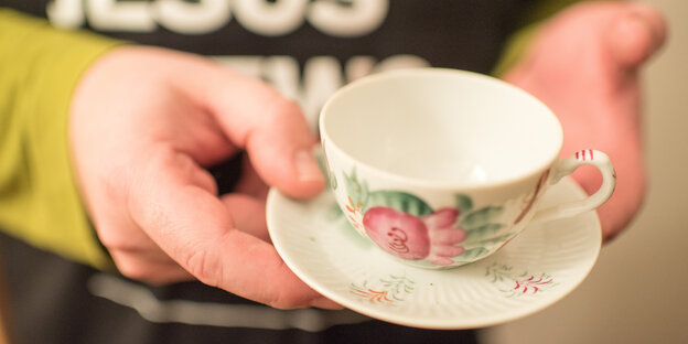 Daniel Konnemann hat eine Tasse in der Hand Daniel Konnemann hat eine Tasse in der Hand