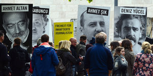 Demonstranten protestieren. Neben ihnen stehen Plakate mit Deniz Yücel und Mehmet Altan