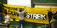 Studenten hängen Bildungsstreik-Transparent im Hörsaal auf