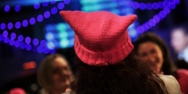 Eine Frau von hinten mit einer pinken Mütze