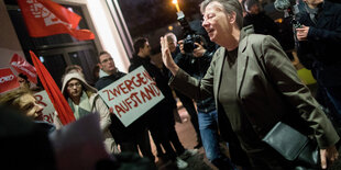 Barbara Hendricks mit grüßender Geste umringt von DemonstrantInnen