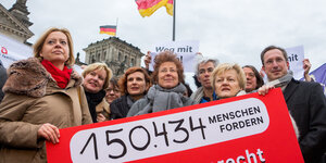 Mehrere Politiker mit einem Anti-§219-Plakat vor dem Reichstag