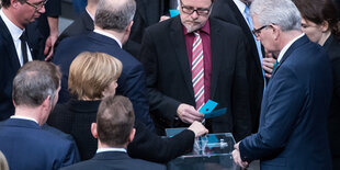 Menschen an einer Wahlurne im Bundestag