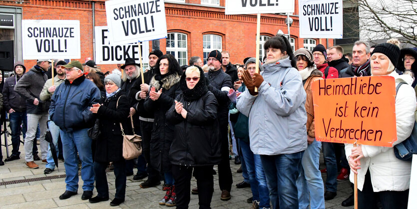 Kundgebungsteilnehmer mit Plakaten auf denen „Schnauze voll!“ steht