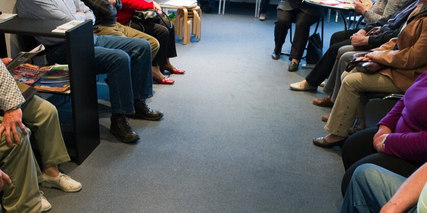 Menschen sitzen in einem Wartezimmer