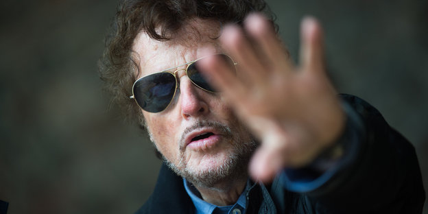 Dieter Wedel mit Sonnenbrille, eine Hand Richtung Kamera gestreckt
