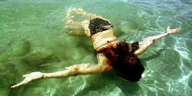 Eine Frau schwimmt unter Wasser
