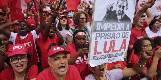 Männer und Frauen in roten Shirts und Käppis demonstrieren für Lula da Silva