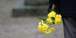 Closeup auf eine Hand, die einen Strauß Blumen hält