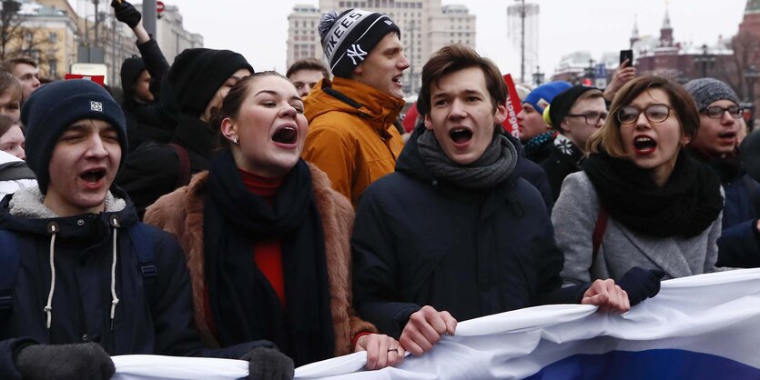 Junge Leute mit russischer Fahne laufen gemeinsam