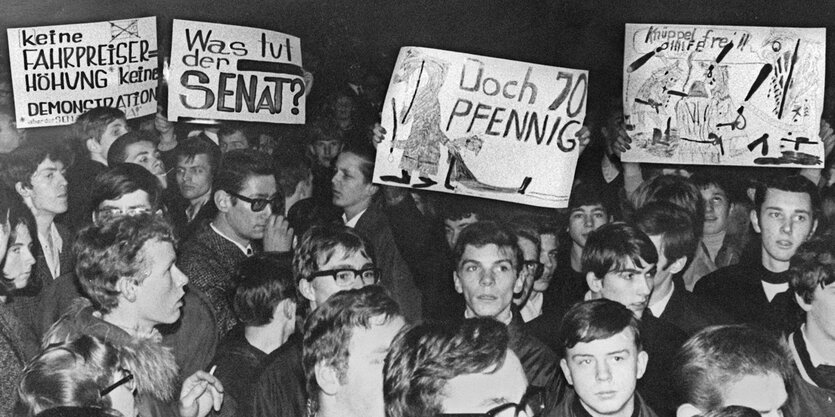 Eine Menschenmenge aus Bremer Schülern, die Plakate gegen die Fahrpreiserhöhung hochhalten. Das Bild stammt aus dem Jahr 1968.