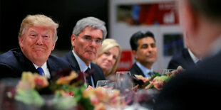 Donald Trump bei einem Dinner in Davos grinst feist