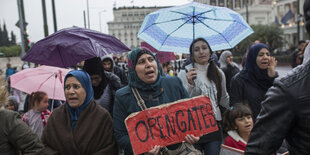 Demonstrierende halten Schild in der Hand mit "Open Gates"