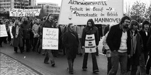 Eine Menschenmenge mit Plakaten geht auf einer Straße in Oldenburg. Die Plakate wenden sich gegen Berufsverbote.