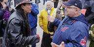 Zwei Männer stehen sich gegenüber und diskutieren, der rechte trägt auf seiner Jacke das alte Logo der Cleveland Indians