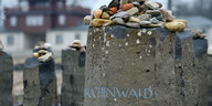 Kleine Steine liegen auf einem Gedenkstein mit der Aufschrift „Buchenwald“