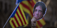 Pro-Katalanische Demonstranten halten ein papiernes Konterfei von Puigdemont hoch
