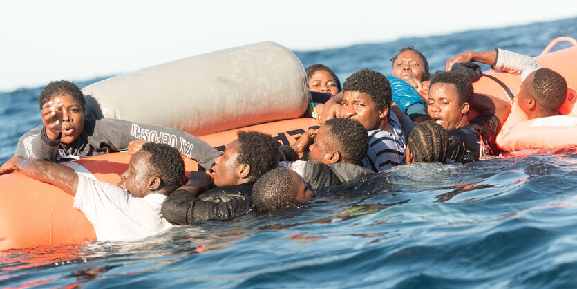 Menschen hängen im Wasser an und auf einem Rettungsschlauch