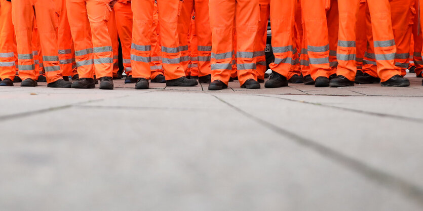 Die Beine vieler Mitarbeiter der Stadtreinigung stehen nebeneinander