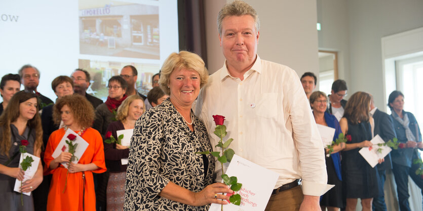 Ein Mann und eine Frau mit Blume und Urkunde