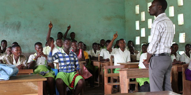 Ein Lehrer steht in einem Schulzimmer in Ghana und unterrichtet