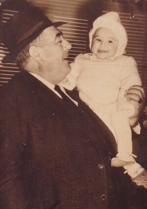 Ein Mann mit Hut hält ein Baby auf dem Arm. Ein Mann mit Hut hält ein Baby auf dem Arm.