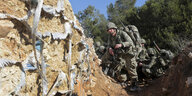 mehrere Soldaten, im Hintergrund Bäume und blauer Himmel