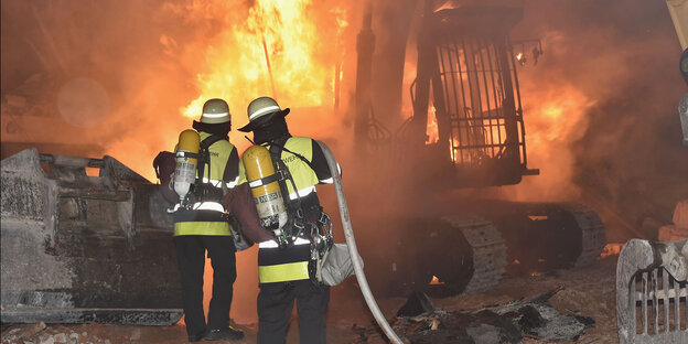 Die Feuerwehr löscht den Brand eines Kettenbaggers