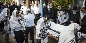 Angehörige und andere Trauernde auf der Beerdigung des ermordeten Rabbiners