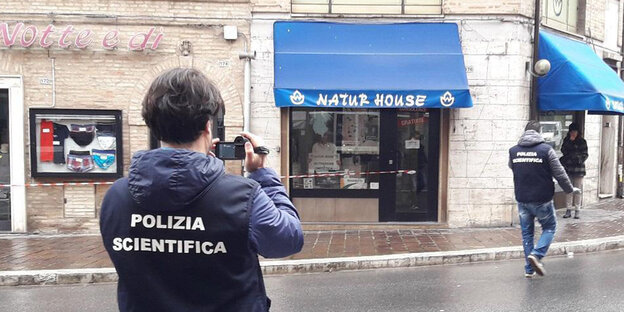 Italienische Kriminaltechniker fotografieren den Ort einer Schießerei