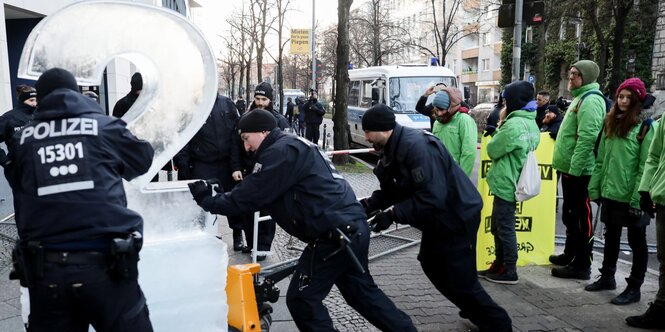 Polizeibeamte entfernen eine große, aus Eis geformte Zwei aus dem Eingangsbereich der SPD-Parteizentrale