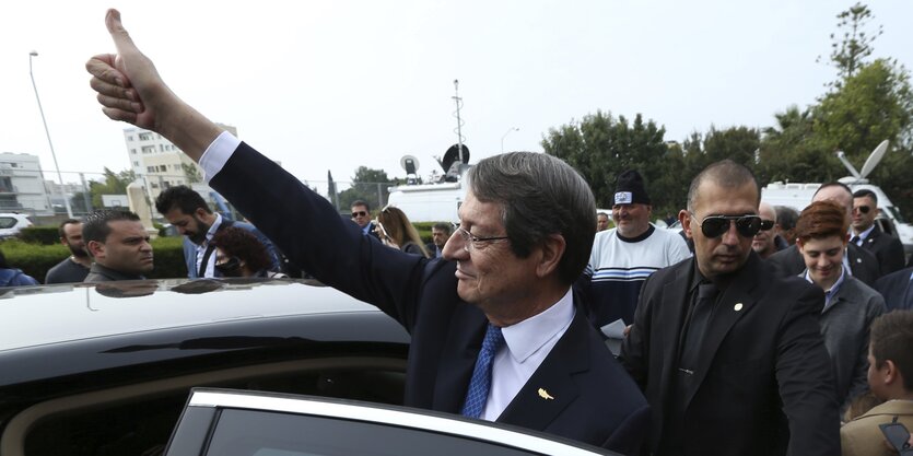 Nikos Anastasiades steht an einem Auto und streckt der Menge einen erhobenen Daumen entgegen