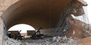 zwei Kanonen unter einer teilweise zerstörten Brücke