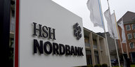 Ein Schild mit dem Schriftzug "HSH Nordbank" steht vor einem niedrigen Flachbau.