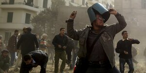 Steine werfende Männer am 11.2.2011 auf dem Tahrir-Platz in Kairo