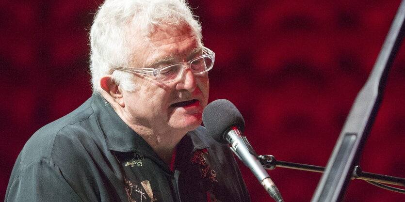 Randy Newman singt in ein Mikrofon