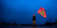 Ein Gewerkschafter trägt bei einer Kundgebung eine IG Metall Fahne.