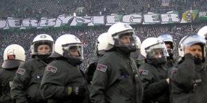 Polizistinnen und Polizisten stehen in Kampfmonitur in einem Fußballstadion