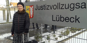 Studentin Loris S. steht mit einem Rollkoffer am Eingang der Justizvollzuganstalt (JVA) Lübeck.