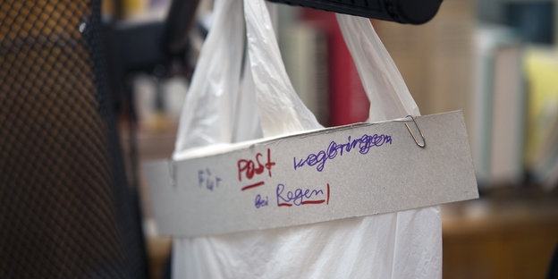 Auf einer Tüte steht "Für Post wegbringen bei Regen" Auf einer Tüte steht "Für Post wegbringen bei Regen"