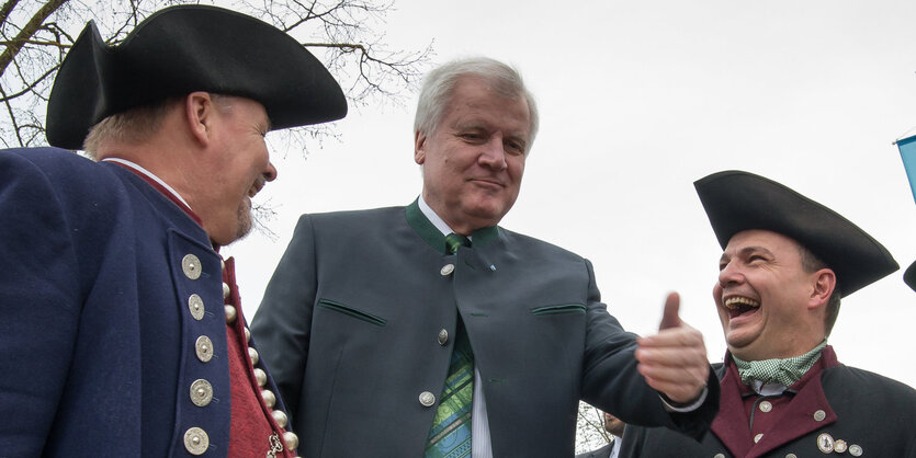 Horst Seehofer steht zwischen zwei Männern in Tracht