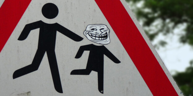 Internet-Meme „Trollface“ auf einem Straßenschild