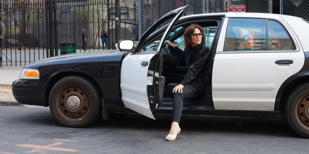 Eine Frau sitzt in einem Polizeiauto