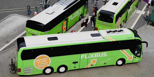 drei grüne Busse auf einem Busbahnhof