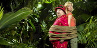 ein Mann und eine Frau sind Rücken an Rücken im Dschungel gefesselt