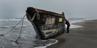 Rumpf eines Holzboots am Strand