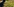 Ein junger Mann mit Brille und Wollmütze steht in einem Treibhaus voller Marihuana-Pflanzen.