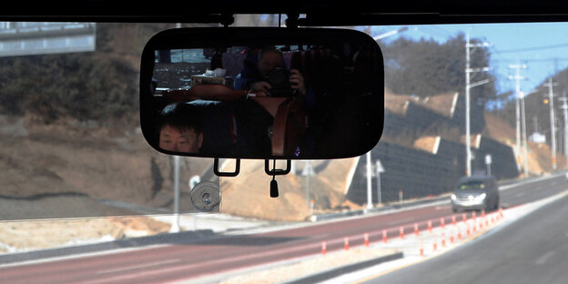 Blick in den Rückspiegel eines Busses auf einer leeren Straße