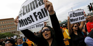 Zwei Frauen halten Schilder mit der Aufschrift „Zuma must fall“ in die Höhe