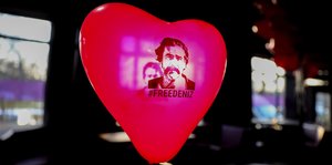 Ein roter Luftballon in Herzform mit dem Konterfei von Deniz Yücel